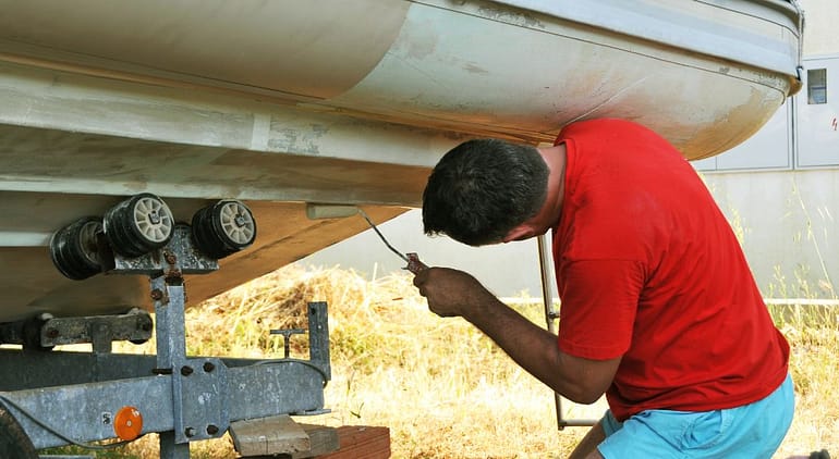 Man performing maintenance on his boat